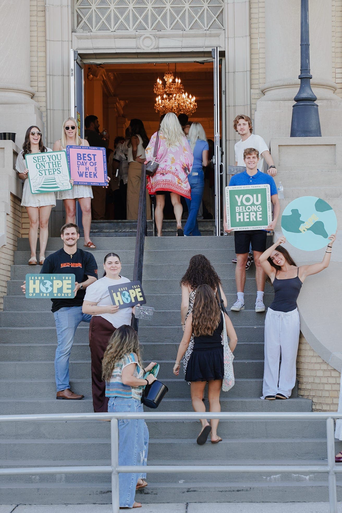 A church welcome team holding printed signs beside the entrance